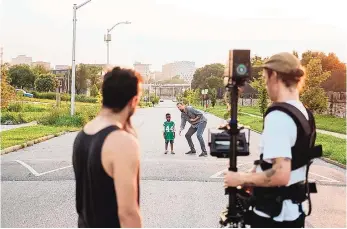  ??  ?? Spencer Grundler and Tyler Davis prepare for a shot as director Darren Durlach chats with King Sullivan for the documentar­y “R.A.W. Tuba: From Sandtown to Symphony.”