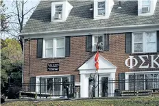  ?? DAKE KANG/THE ASSOCIATED PRESS ?? Brothers of the Phi Sigma Kappa Epsilon fraternity house take down a flag at Ohio State University last week in Columbus, Ohio.