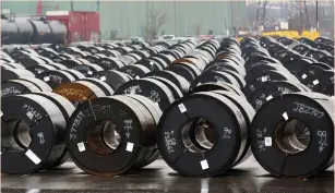  ?? (Peter Power/Reuters) ?? STORED ROLLS of steel are seen outside the ArcelorMit­tal Dofasco plant, an integrated steel producer, in Hamilton, Ontario, last month.