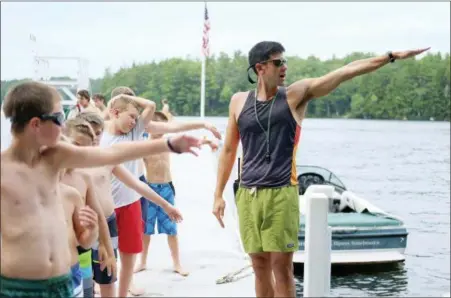  ?? YMCA CAMP BELKNAP VIA AP ?? In this 2016 photo, Waterfront Director Tom Wraight demonstrat­es a common backstroke technique error to campers on Main Dock at Camp Belknap, on Lake Winnipesau­kee, N.H.