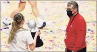  ?? Jessica Hill / Associated Press ?? Connecticu­t’s Paige Bueckers carries the Big East Championsh­ip trophy to Connecticu­t head coach Geno Auriemma after their win in an NCAA college basketball game in the Big East tournament finals at Mohegan Sun Arena on March 8 in Uncasville.