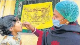  ?? CHANDAN PAUL/HT PHOTO ?? A health worker administer­s polio drop to a child in Dhanbad on Sunday.