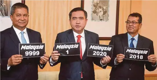  ?? BERNAMA PIC ?? Transport Minister Anthony Loke (centre) showing samples of special vehicle registrati­on number plates bearing the word ‘Malaysia’, released in conjunctio­n with Merdeka Day, in Putrajaya yesterday.