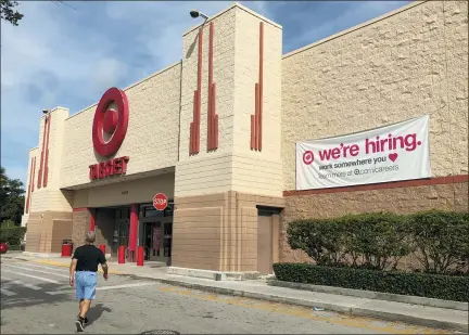  ?? WILFREDO LEE — THE ASSOCIATED PRESS ?? A “we’re hiring,” sign hangs on the side of a Target store in North Miami Beach, Fla. On Tuesday, the Labor Department reported on job openings and labor turnover for September.