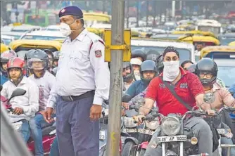  ?? RAJ K RAJ/HT PHOTO ?? A traffic policeman wearing an air filter mask regulates traffic at a busy junction in Delhi. According to a study by IITKanpur, pollution from vehicles in Delhi grew from 64% to 72% between 1999 and 2000.