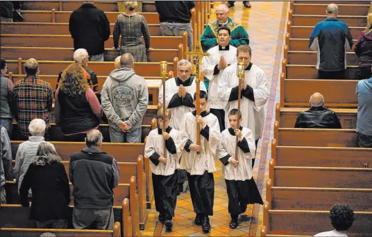  ?? Robert F. Bukaty The Associated Press ?? Altar boys and priests walk down the center aisle Sunday at the Basilica of Saints Peter and Paul in Lewiston, Maine.