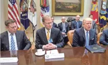  ??  ?? Elon Musk, left, and other business leaders such as Corning CEO Wendell Weeks, center, meet with President Trump at the White House on Jan. 23. NICHOLAS KAMM, AFP/GETTY IMAGES