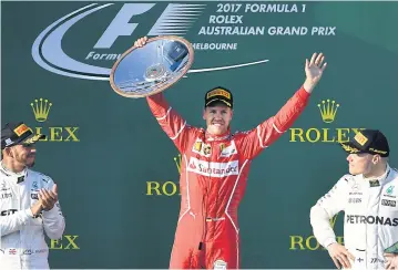  ?? AFP ?? Ferrari’s Sebastian Vettel, centre, celebrates on the podium with Mercedes’ Lewis Hamilton, left, and Valtteri Bottas.