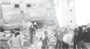  ??  ?? People gather near a destroyed building said to be a Medecins Sans Frontieres (MSF) supported hospital in Marat al Numan, Idlib, Syria in this still image taken from a video on a social media website. — Reuters photo