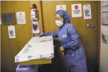  ?? Gabrielle Lurie / The Chronicle ?? Cho Lee, a nurse on the COVID19 floor at St. Francis Hospital, sanitizes her hands to check on a patient April 6.