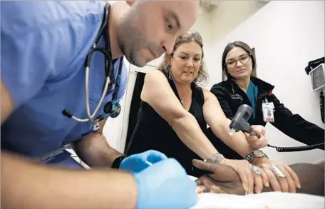  ?? Photograph­s by Francine Orr Los Angeles Times ?? DR. SUSAN PARTOVI, center, with Drs. Andrew Frerking and Lisa Altieri. Partovi is an advocate for interventi­on for the homeless.