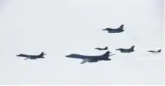  ?? —AFP ?? IN THE AIR: This handout photo shows B-1B Lancers (left and 2nd left) flying over South Korea during a South Korea-US joint live fire drill conducted at a range in Yeongwol County.