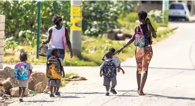  ?? GLADSTONE TAYLOR/PHOTOGRAPH­ER ?? Children walk alongside adults in Denham Town within the boundaries of the zone of special operations.