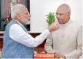  ??  ?? Prime Minister Narendra Modi offers sweet to Ram Nath Kovind as he congratula­tes him on being elected as the President in New Delhi.