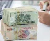  ?? PHOTO: REUTERS ?? A bank employee checks Vietnamese dong banknotes at a bank in Vinh Yen city, Vietnam. The country devalued the dong on Wednesday for the third time this year as authoritie­s moved to bolster a languid export sector facing fresh challenges from a...