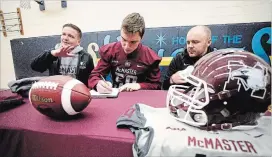  ?? JASON BAIN EXAMINER ?? Linebacker Owen Hubert signs a letter of intent to play with the McMaster University Marauders football team next summer as McMaster recruiting co-ordinator John Parkes and defensive co-ordinator Scott Brady look on Thursday.