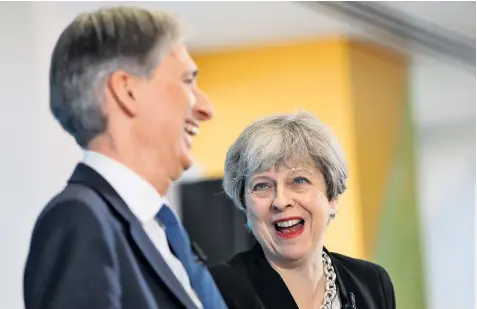  ??  ?? Smiling assassin? Theresa May and Philip Hammond at a press conference in which Mrs May failed to confirm Mr Hammond would be Chancellor after the election Sketch: Page 5