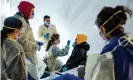  ??  ?? Doctors test hospital staff for coronaviru­s outside the St Barnabas hospital in New York. White House projection­s show 100,000 Americans could be killed by the virus. Photograph: Misha Friedman/Getty Images