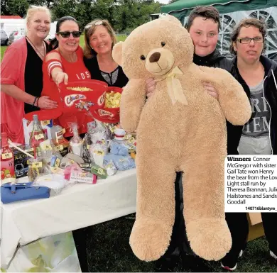  ??  ?? Winners Conner Mcgregor with sister Gail Tate won Henry the bear from the Love Light stall run by Theresa Brannan, Julie Hailstones and Sandra Goodall
140716blan­tyre_07