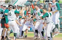  ?? AL DIAZ/MIAMI HERALD ?? The Hurricanes baseball team awaits third baseman Edgar Michelange­li at home plate after his game-winning home run in the tenth inning.