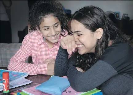  ?? ALLEN McINNIS ?? Sisters Saja Al Mahamid, left, and Raniah Al Mahamid share a laugh at their home on Friday while they express varying opinions about returning to school. Saja wants to be a doctor while Raniah would like to be a journalist.