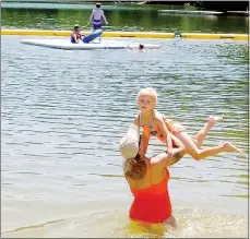  ?? Lynn Atkins/The Weekly Vista ?? Heather Stoops holds her daughter, Tatum, out of the water at the Lake Avalon Beach. Both are California residents who were guests of Heather’s mother, a Bella Vista resident.