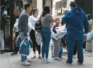  ?? E. JASON WAMBSGANS/CHICAGO TRIBUNE ?? Migrants from the Texas border arrive in a chartered bus Friday at Chicago’s Union Station. They were transferre­d to CTA buses.