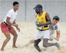  ??  ?? TAG TOUCH: Jason Raubenheim­er, Ashley Wait and Sandile Ndlondlo (with ball) play rugby on the sand