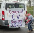  ??  ?? Mr. Pisaneschi decorates a school van before he and other teachers deliver packages to graduating seniors.