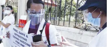  ?? Associated Press ?? ↑
A health worker holds a slogan during a protest outside the Philippine General Hospital in Manila on Friday.