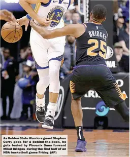  ??  ?? As Golden State Warriors guard Stephen Curry goes for a behind-the-back, he gets fouled by Phoenix Suns forward Mikal Bridges during the first half of an NBA basketball game Friday. (AP)