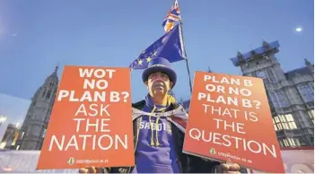  ??  ?? ► Un manifestan­te pro-Europa sostiene pancartas cerca del Parlamento en Londres, ayer.