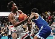  ?? Joe Buglewicz/Getty Images ?? UConn guard Nahiem Alleyne and Seton Hall’s Femi Odukale fight for the loose ball during the first half on Saturday in Storrs.