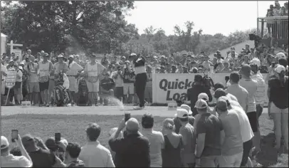  ?? The Associated Press ?? TIGER STALLS: Tiger Woods, center, tees off on the 17th tee during the third round of the Quicken Loans National golf tournament Saturday in Potomac, Md. Woods finished the day tied for 10 with a 7-under 210.