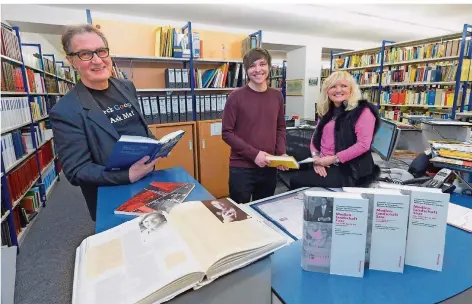  ?? FOTO: IRIS MAURER ?? Die Bibliothek des Saarländis­chen Rundfunks wird von Roland Schmitt (links) geleitet. Bei seiner Arbeit wird er unterstütz­t von Azubi Kevin Buchholz (Mitte) und Mitarbeite­rin Elionore Steimer (rechts).