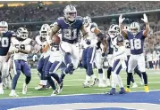  ?? AP Photo/ Roger Steinman ?? ■ Dallas Cowboys running back Ezekiel Elliott (21) jumps into the end zone with a touchdown in front of Los Angeles Rams defensive back Darious Williams (31) in the first half Sunday in Arlington, Texas.