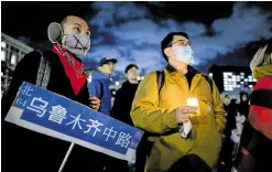  ?? —AFP ?? SYMPATHY A man holds a candle as people gather at New York’s Columbia University in support of protests in China calling for an end to COVID-19 lockdowns.