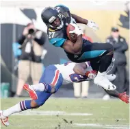  ?? AP ?? Jacksonvil­le Jaguars running back Leonard Fournette (top) makes a reception over Buffalo Bills defensive back Leonard Johnson in the second half of an NFL wild-card playoff game in Jacksonvil­le, Florida, yesterday.