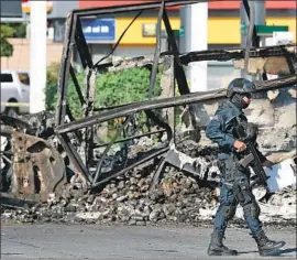  ?? Alfredo Estrella AFP/Getty Images By Kate Linthicum and Cecilia Sanchez ?? A POLICEMAN patrols in Culiacan a day after an all-out battle by cartel members prompted Mexican security forces to release a drug lord they had arrested.