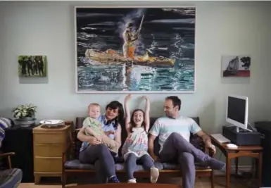  ?? COLE BURSTON FOR THE TORONTO STAR ?? Nadia Tasci and Uros Jelic in their living room with daughter Katya, 6, and son Theo, 2, beneath one of Jelic’s paintings.