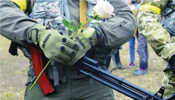  ?? AP ?? Miembros del ejército ucraniano sostienen una flor en la boda de dos compañeros ayer en Kiev (Ucrania)