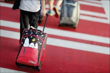  ?? DAVID GOLDMAN — THE ASSOCIATED PRESS FILE ?? In this file photo, a child pulls a suitcase along a crosswalk upon arriving at Hartsfield-Jackson Atlanta Internatio­nal Airport ahead of the Thanksgivi­ng holiday in Atlanta. Parents may be feeling pressure to pay more money to sit with their young children on crowded planes despite a push by Congress to make airlines let families sit together at no extra cost. A consumer group has protested to Transporta­tion Secretary Elaine Chao, asking her to begin writing regulation­s over the airlines’ family-seating policies.