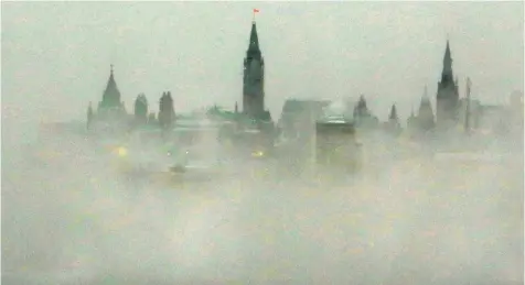  ?? FRED CHARTRAND/ THE CANADIAN PRESS ?? Parliament Hill, is shrouded with early morning ice fog from the Ottawa River in Ottawa, Friday. Heritage Canada has announced an event will be canceled because of the extreme cold weather conditions leading up to News Years Day.