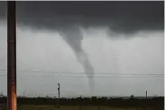  ?? Joseph Rushmore / New York Times ?? A tornado passes just south of Perry, Okla., on Monday. Forecaster­s warned that more than 2 million people lie in the path of a series of storms.