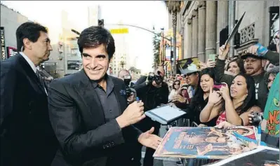  ?? ERIC CHARBONNEA­U / GTRES ?? El mago David Copperfiel­d firmando autógrafos en Los Ángeles en marzo del 2013