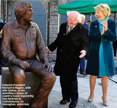  ??  ?? Unfazed: President Michael D Higgins, with wife Sabina, at the unveiling a statue of country music legend Big Tom McBride in Castleblay­ney, Co. Monaghan, yesterday