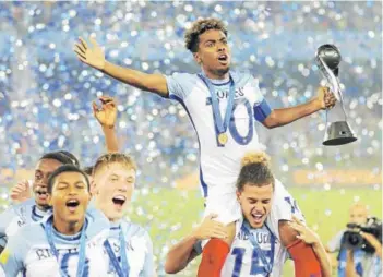  ??  ?? ► Angel Gomes, en andas, celebra con la copa de campeón mundial Sub 17.