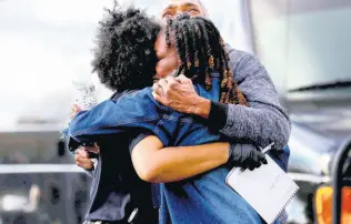  ?? ?? A Memphis police officer hugs the family of rapper Young Dolph after he was killed outside of a store in Memphis,Tennessee, Wednesday. Young Dolph was widely admired in the hip-hop community for his authentici­ty and fierce independen­ce.