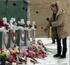  ?? Nam Y. Huh/AP ?? A woman places flowers at a makeshift memorial on Feb. 17 in Aurora, Ill., near Henry Pratt Co.. where several were killed on Friday.