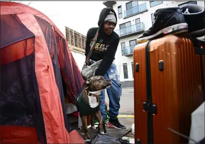  ?? ?? Homeless camper Marlene Middleton and her dog, Cash, pack up at a tent encampment along East 18th Avenue and North Marion Street in Denver last week.